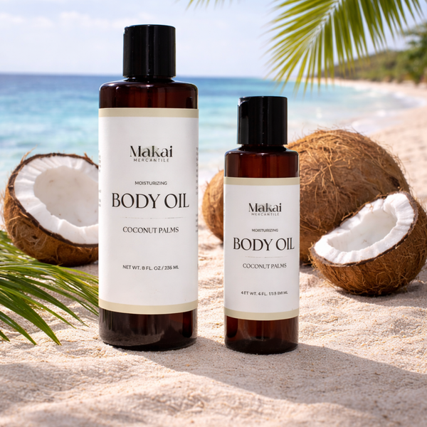 Two bottles of Makai Mercantile body oil with coconuts on a beach.