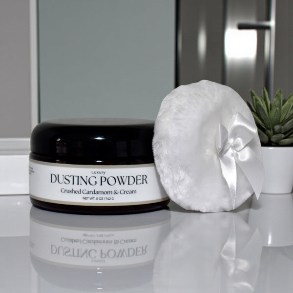 Dusting powder jar with a puff on a reflective surface