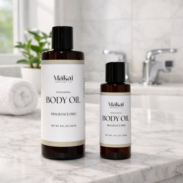 Two bottles of Makai Mercantile body oil on a marble countertop with a bathroom setting. Fragrance Free Body Oil.