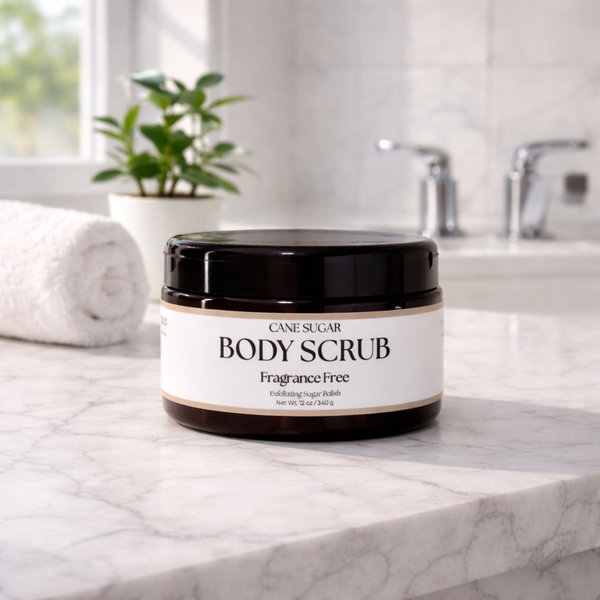 Jar of  fragrance free cane sugar body scrub on a bathroom counter with a plant and sink in the background.
