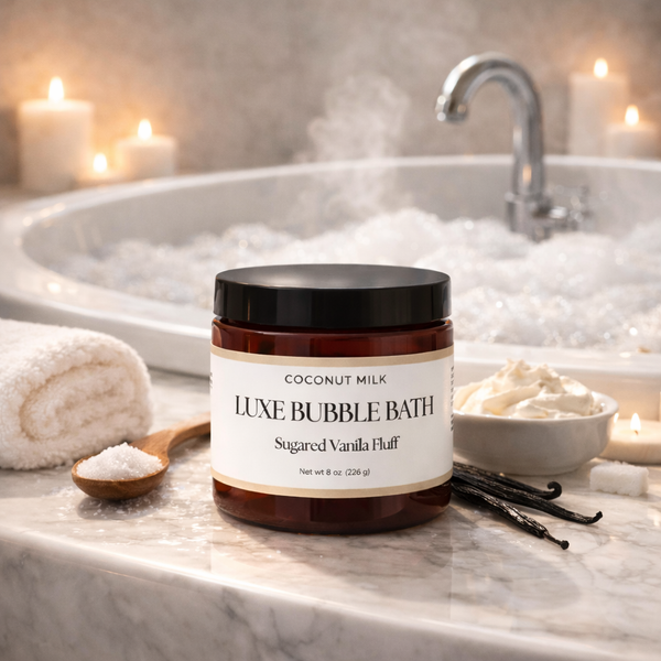 Jar of Luxe Bubble Bath with a bathtub and candles in the background