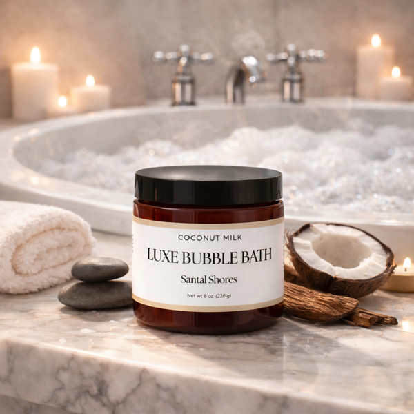 Jar of Luxe Bubble Bath on a bathroom counter with a bathtub and candles in the background