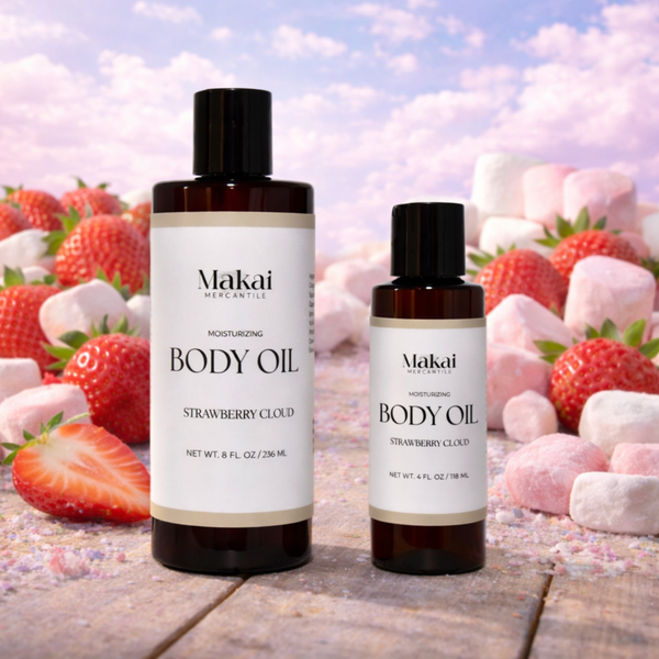 Two bottles of Makai Mercantile body oil with strawberries and pink marshmallows in the background.